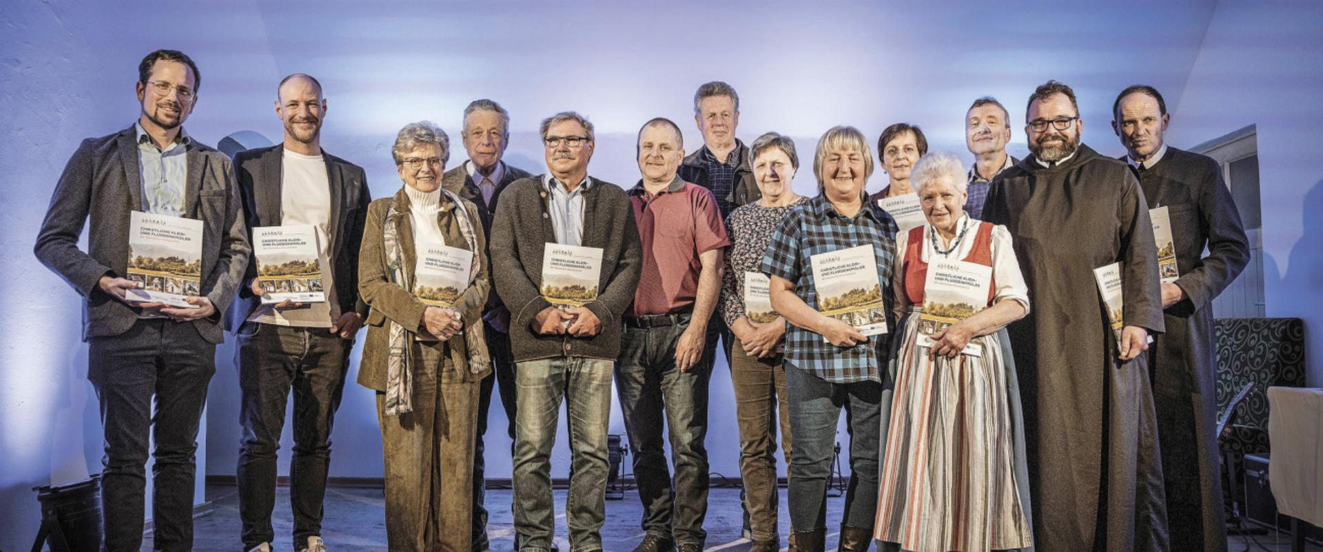 Mitglieder des Seelsorgeraums Eisenwurzen bei der Übergabe des „Marterlbuches“: Oliver Gulas-Wöhri, Martin Gebeshuber, Elisabeth Fuxjäger, Manfred Fössleitner, Werner Huber, Hermann Kain, Alexander Maunz, Eleonora Fluch, Renate Groiß, Loretta Kain, Friederike Amort, Hans Hintsteiner, Pater Ulrich und Pater Engelbert (von links). Foto: Nachbagauer - Das Bild wird blockiert. – Möglicherweise durch einen aktiven Adblocker.