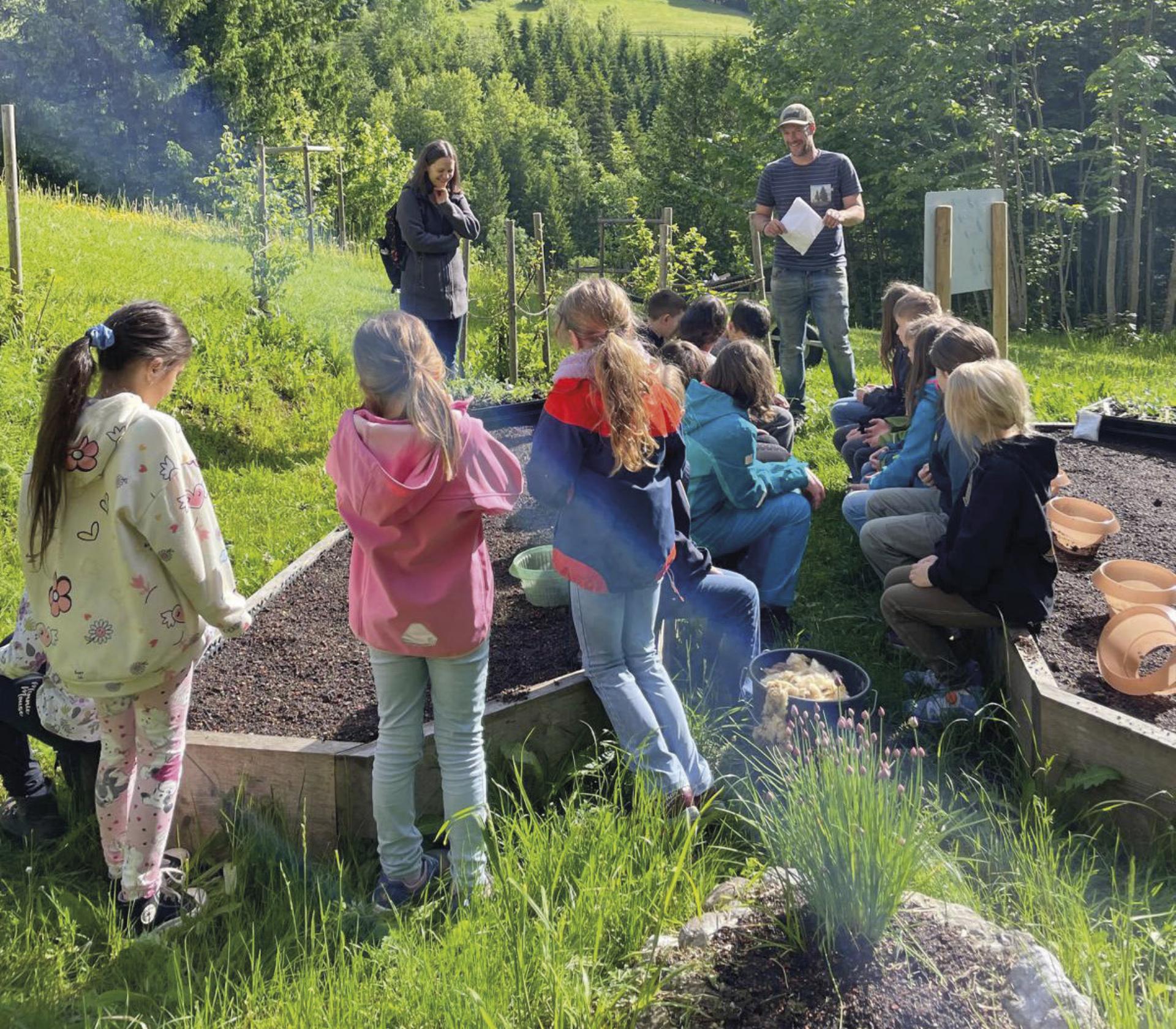 Kinder beim Pflanzen in klimawandelangepassten Gärten.