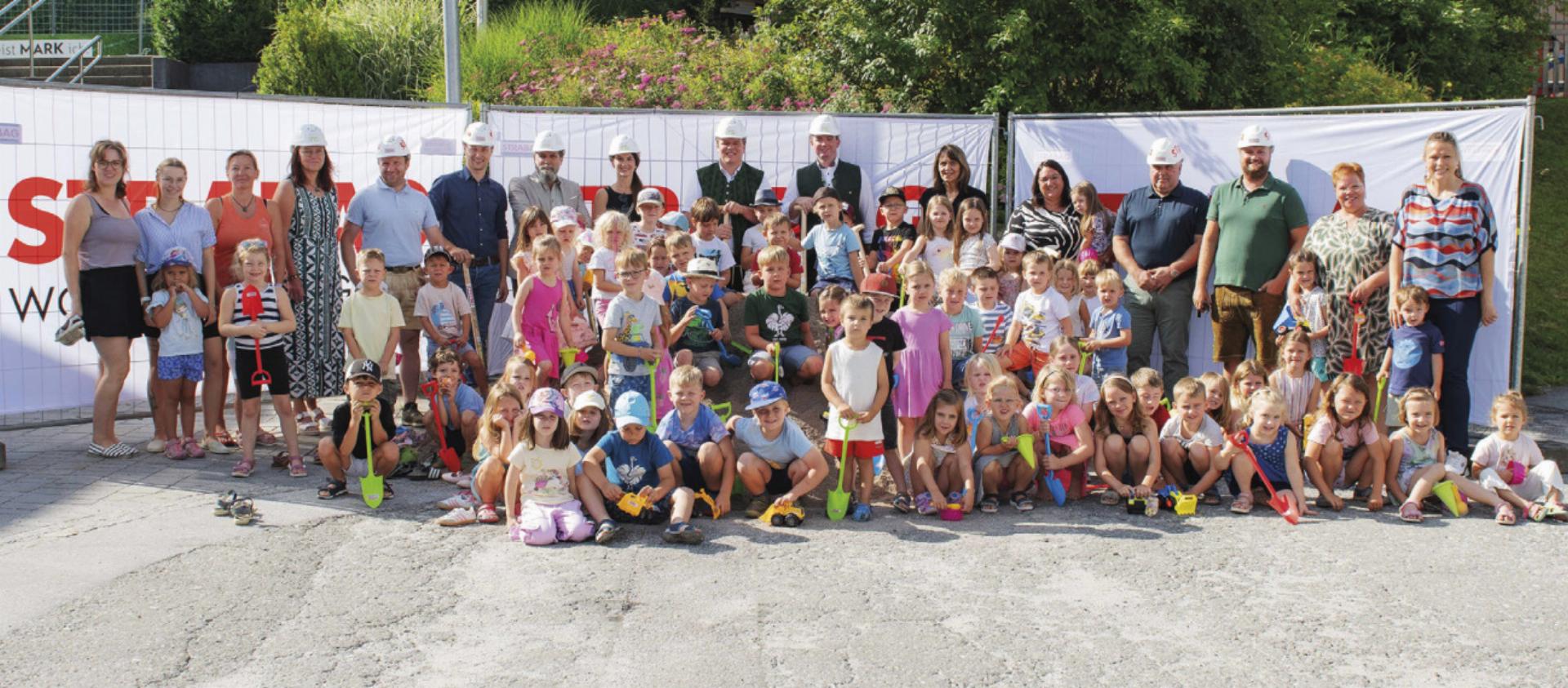 Kommunalpolitiker und Vertreter der ausführenden Firmen vollzogen gemeinsam mit den Kindergartenkindern den Spatenstich. Foto: Ennstaler