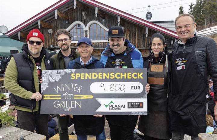 Daniel Ipser, Geschäftsführer Weber Grill, Mario Edler vom SOS Kinderdorf, Michael Krainer, Aufsichtsratsvorsitzender Planai-Hochwurzen-Bahnen, Starkoch Johann Lafer, Yulia Haybäck und Georg Bliem, Geschäftsführer Planai-Hochwurzen-Bahnen (von li.), beim Wintergrillen auf der Planai. Foto: Harald Steiner