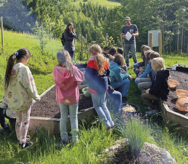 Kinder beim Pflanzen in klimawandelangepassten Gärten.