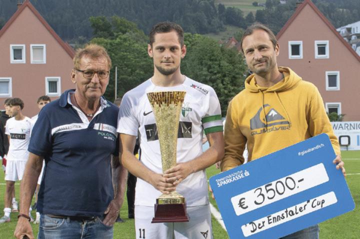 SC-Liezen-Kapitän Dominik Presul nahm die Siegestrophäe von Sportreporter Werner Rohrer (links) und Chefredakteur Stephan Fuchs (rechts) entgegen. Foto: Ennstaler